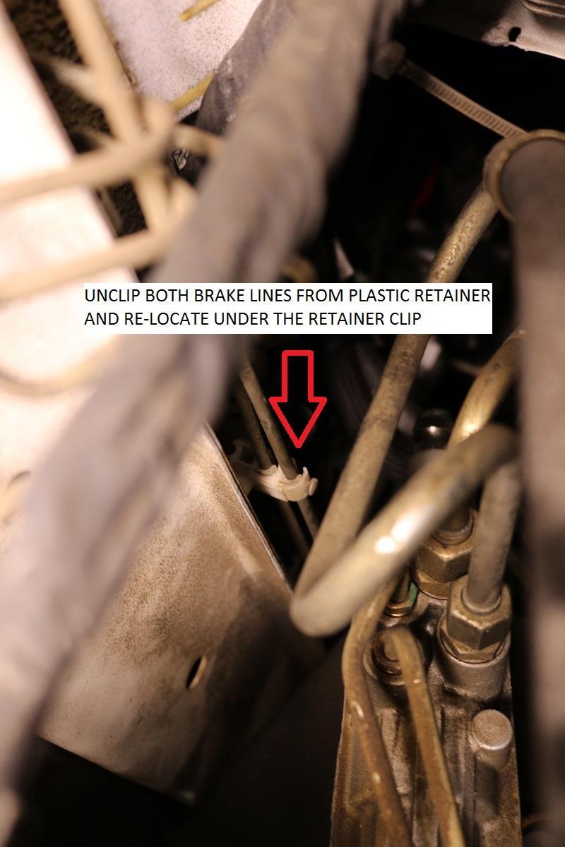 18) Remove the upper spring stop plate from the lower control arm.