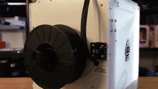 Press the dial to select "Ready". Now Insert the 1.75mm filament into the opening near the bottom of the feeder. The motor will slowly feed the filament through the guide tube.