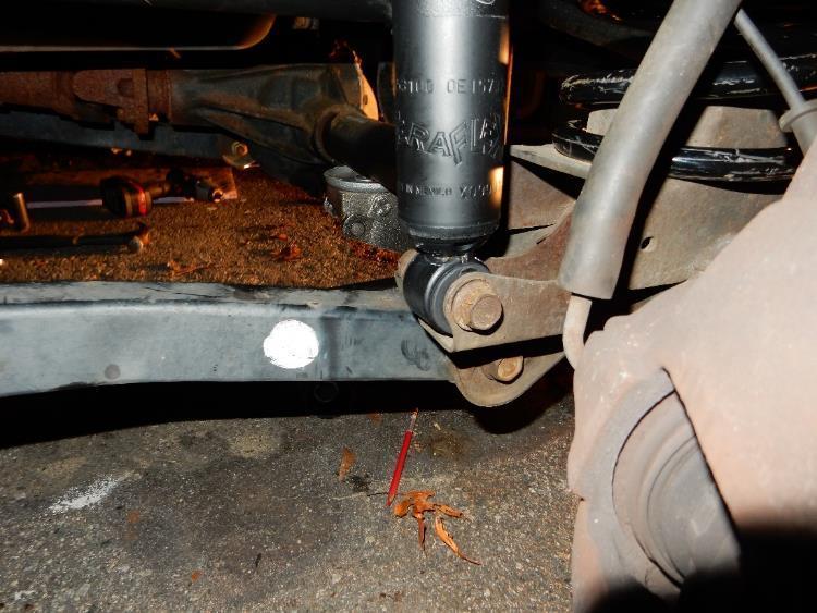 Install the remaining rubber bushing, retaining washer, and nut onto the shock shaft on the driver and passenger sides.