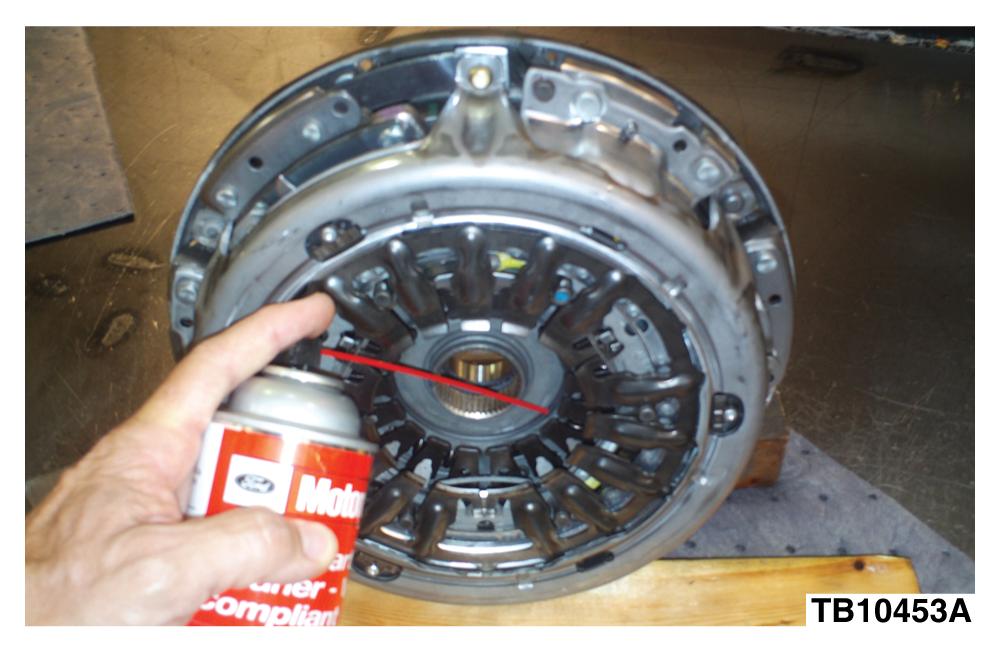 Spray Motorcraft Metal Brake Parts Cleaner or equivalent that contains 60% acetone in a downward direction on each friction disc.