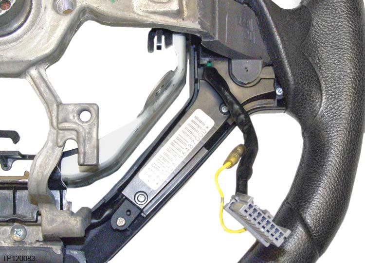 7. Turn over the steering wheel assembly and detach the harness from the clip. Next, move the harness to the side.