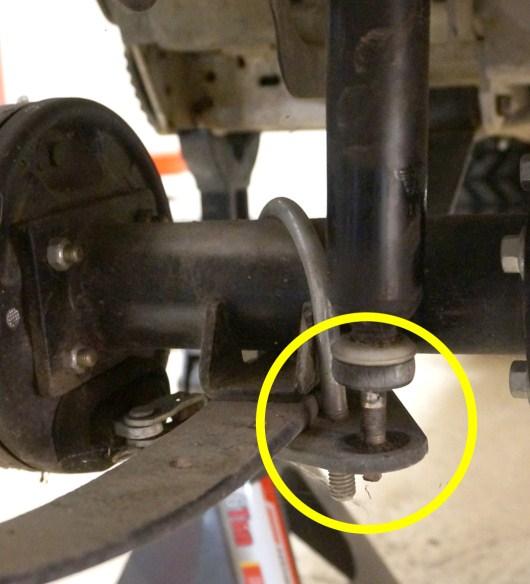 For safety reasons, complete one side of the suspension at a time. The photos below show the Driver side. 1. Unbolt the bottom portion of the driver side shock from the shock mounting plate.