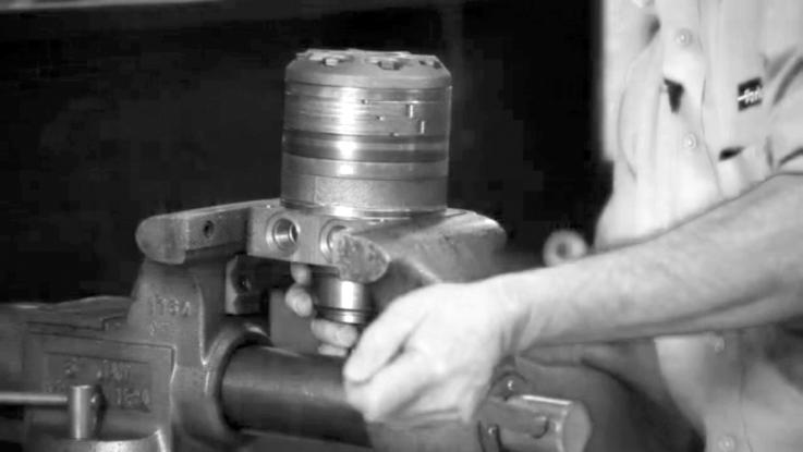 the vise jaws clamping firmly on the sides of the housing (19) mounting flange. SEE FIGURE 1.