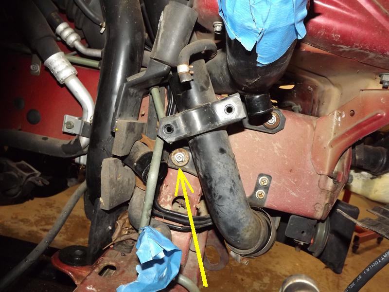 Remove the mid pipe bracket bolt on the forward charge pipe.