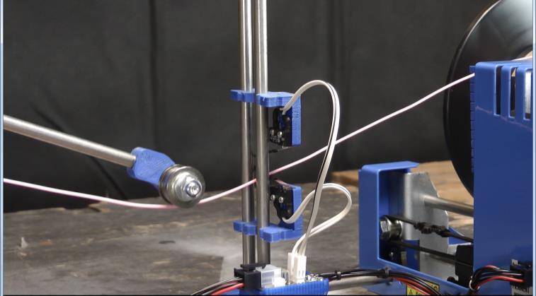 EXAMPLE SETUP - AUTOSPOOLER Filament tensioning arm, the wheel at the end of the arm keeps the filament taught and also pushes it downwards to interact with the lower microswitch.