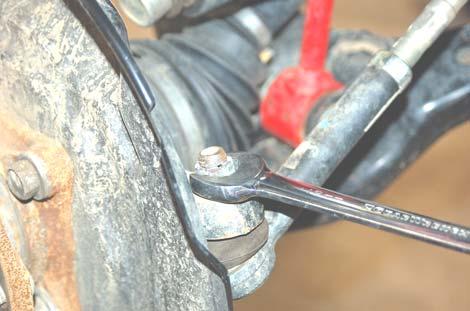Using a 19mm wrench, remove the outer tie rod end nut and separate from the knuckle. Retain stock nut for reuse.
