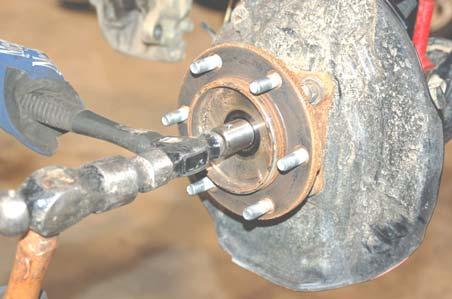 Using a 35mm socket, remove the axle retaining nut. Retain stock hardware for re-use. See PHOTO 8. PHOTO 7 PHOTO 8 15.