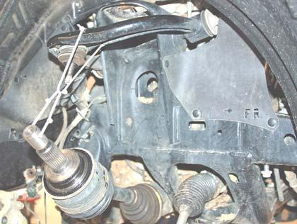 17. Remove the upper ball joint nut from the upper control arm using a 19mm wrench.