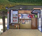 outdoor kitchen comes complete with a refrigerator, Coleman grill, TV outlet, storage, plus a sink