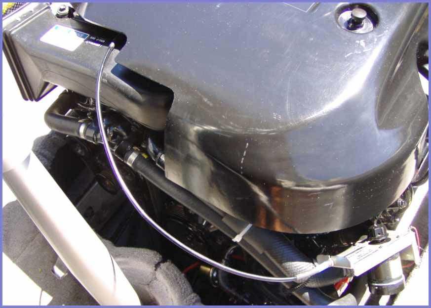 If desired, you can cut a 4 x6 section of the engine cover away to accommodate the cable