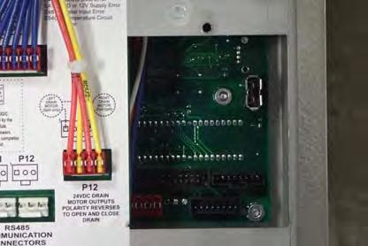 33 Use a Phillips head screwdriver to remove the existing cover from the back of the control board. 34 Locate the USB port on the back of the controls.