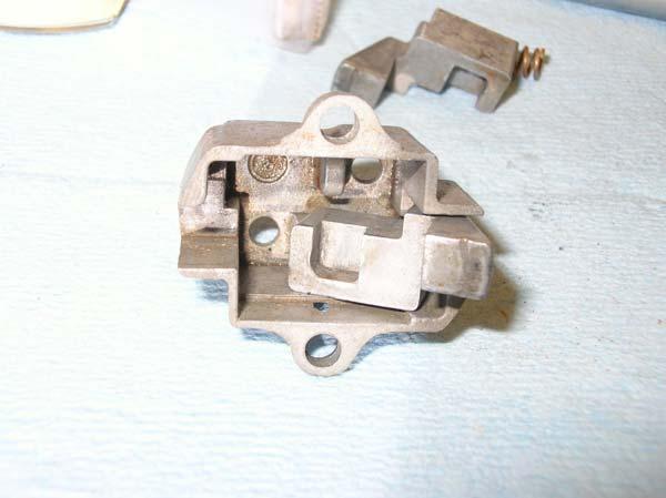 Then angle the latch ear into the housing so that the end of the spring catches on its post.