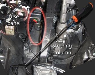 It is located just to the left of the clutch pedal return spring mechanism, highlighted here inside the orange oval.