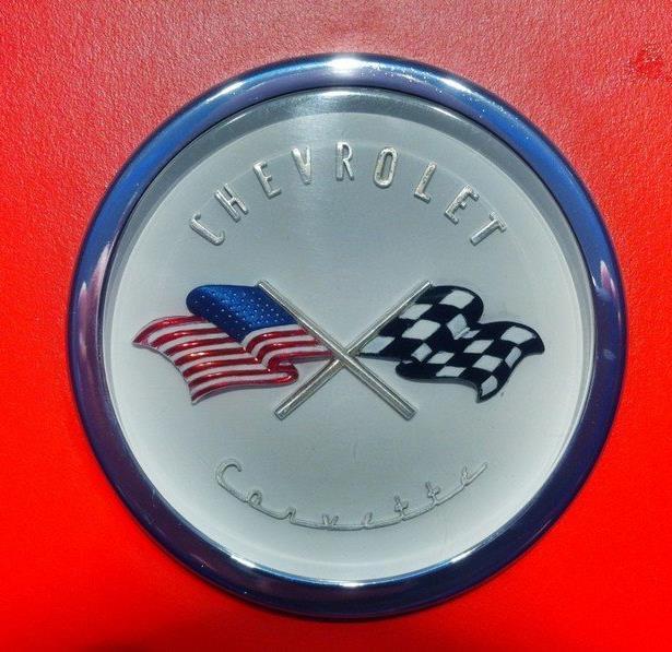 The original emblem design utilized a checkered racing flag and the U.S. Flag in the design.
