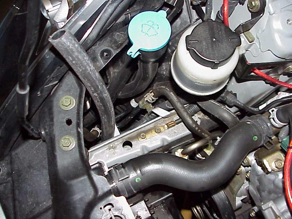 hole shown by the arrow in PHOTO 28. Route the positive wire for the pump into the engine compartment by the battery and leave there for now. Connect the negative wire to a suitable chassis ground.