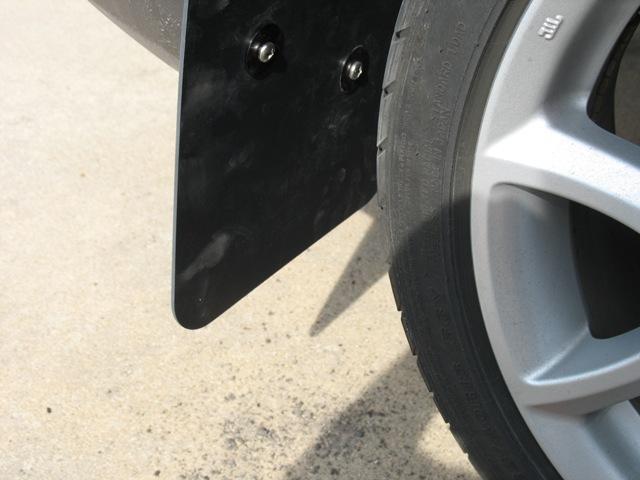 8. Begin installing the right rear mud flap with the textured side facing the rear of the vehicle by threading 2 of