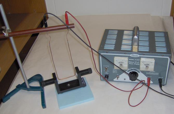 See figure on the left - Connect the power supply leads to the jacks on the deflected bar apparatus. Once the current is flowing (LIMIT TO 3 AMPS), the wire will deflect.