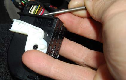 Step 25: Disconnect the black connector by pushing in on the release tab and pulling down on the white engagement lever.