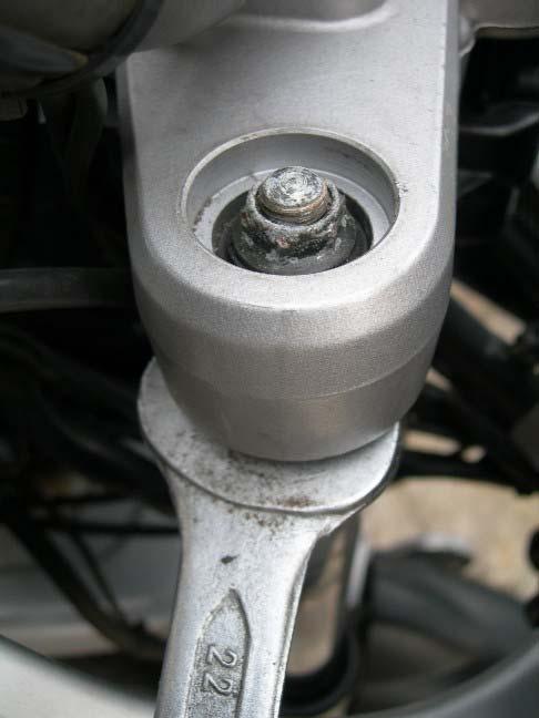 Place a 22 mm spanner on the flats at the top of the leg,