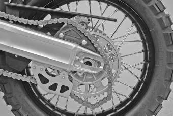 Carefully lift the rear wheel out of the swing arm. Do not operate the rear brake when the rear wheel has been dismounted.