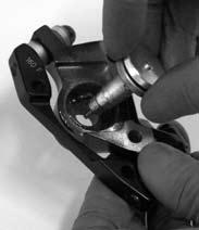 Lightly grease the ramps of the fixed cam in the outboard caliper