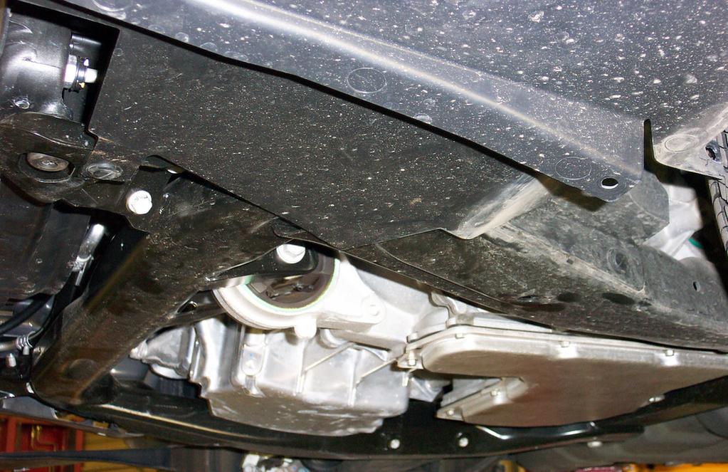 On the driver's side, remove two plastic fasteners located along the inside lower edge of the splash shield (Fig.
