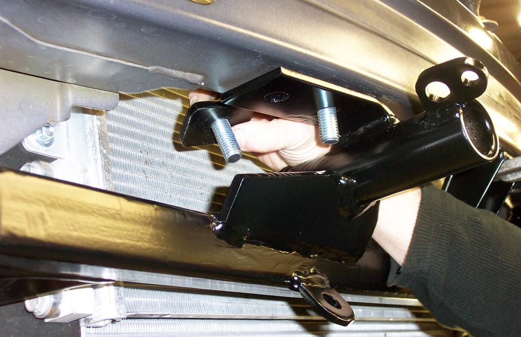 Using the pre-existing upper mounting points of the main receiver brace as templates, drill four ½" holes through the bottom of the bumper core