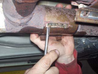 STEP 4: Use a screwdriver to lift retaining clip on clamp at rear