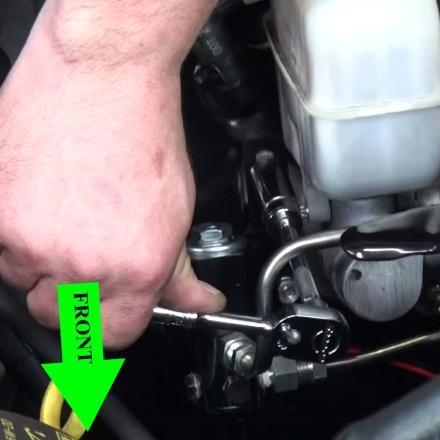Gently push the OEM brake line slightly down to allow the mounting bracket hole to match up with the Master Cylinder stud.