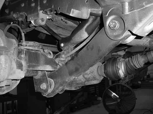 Working on one side of the vehicle at a time, remove the lower control arm from the vehicle.