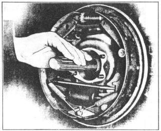 Place bearing adjusting shims over axle and against backing plate. 6. Place adjusting cap over axle and secure with lockwashers and nuts. 17.
