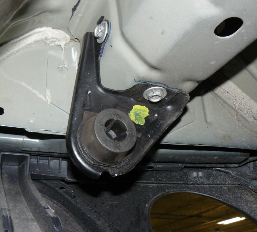 Remove the 13mm bolts securing the hanger brackets located at the rear of the vehicle, shown by the arrows in Figure 3.