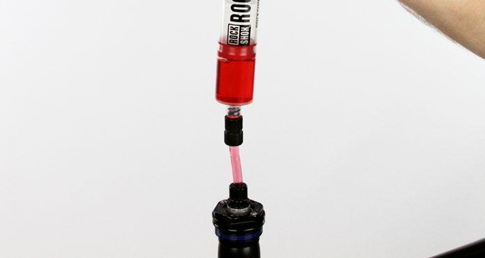 5 Fill the RockShox Charger bleed syringe half full with 3wt suspension oil and thread the syringe and Charger hose fitting into the compression
