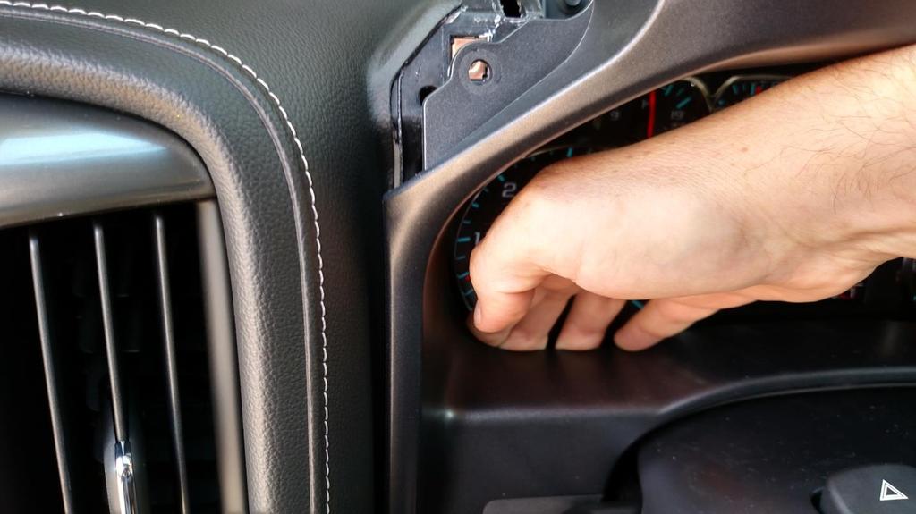 8. Once the upper portion of the kick panel has been released, grasp the lever for the telescoping wheel