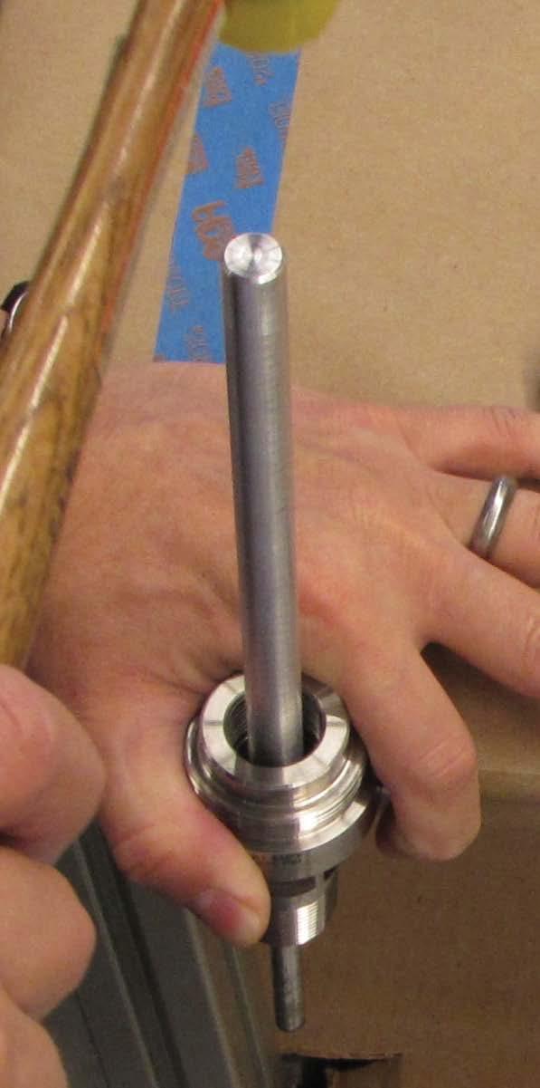 7. Carefully tap the bearing removal tool to pass the bearing spring through the bore.
