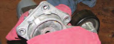 Use a 10mm socket to loosen the three bolts that hold the tensioner in place and remove