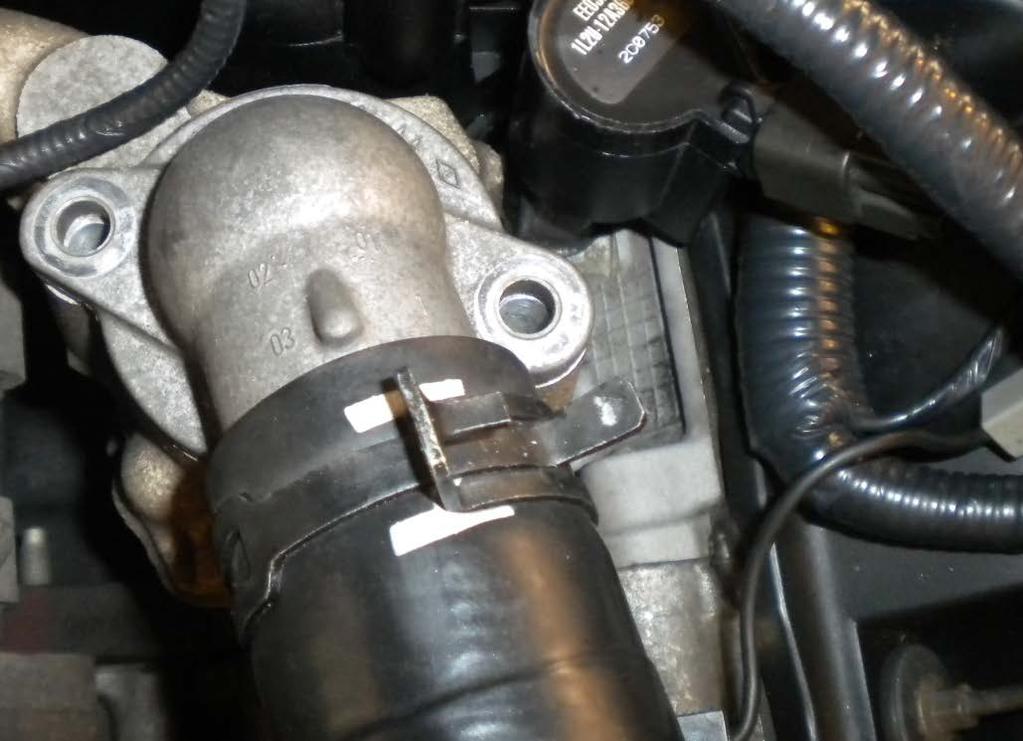 11. Remove the two 10mm bolts holding the thermostat housing. Once the bolts are removed, have several rags arranged around the thermostat housing, and then lift up.