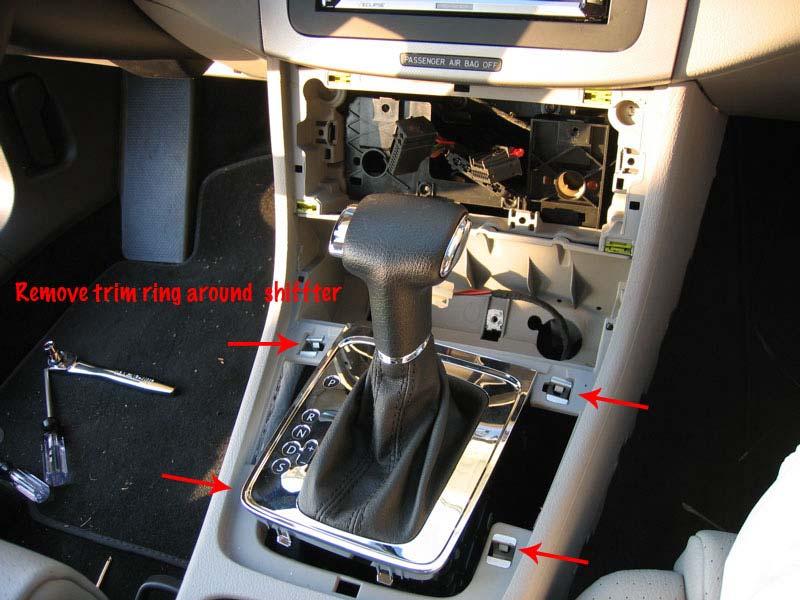 Unplug these. 2.11 Once the trim piece surrounding the shifter is removed then you can remove the ash tray bracket you unfastened in 2.7 above. 2.12 Reach behing vent controls and unplug the spring mechanism to release the console.