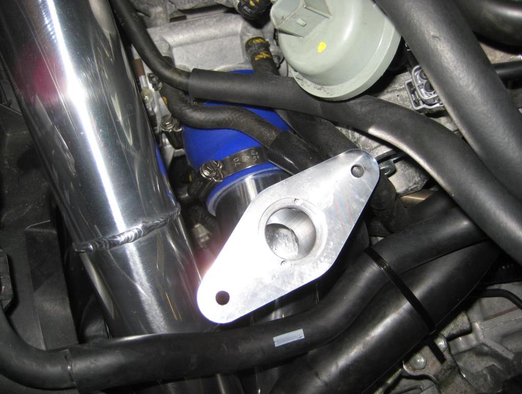 LOWER of the two 90 degree bends on the intercooler. The hardpipes should not touch at any point.