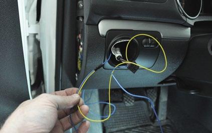 Step 12: Gently pull the excess blue wire up through the opening for the headlight switch, then tape the end of the yellow wire to it near the opening in the dash.