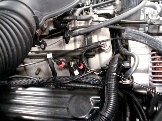 Coolant Sensor is located under the hose. Figure 6 4. Cut the tan with black stripe wire for the coolant sensor about halfway between the sensor and where the wire goes into the harness.