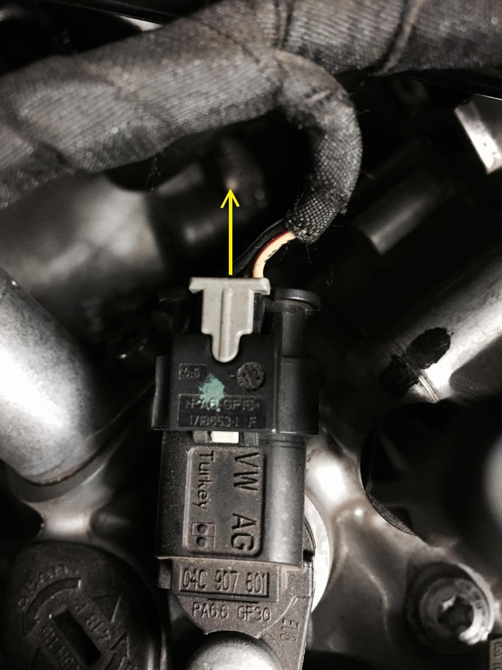 PLUG A: Remove the plug from the camshaft sensor by sliding back the grey tab all the way back and then pushing it down.