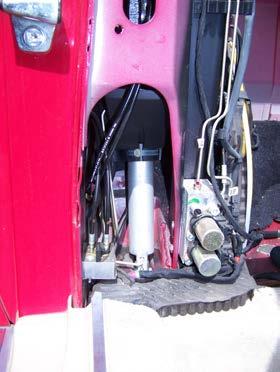 If you want to take out the boot with the cylinder, pull the drain hose upward out of the chassis and maneuver the hydraulic line through the cutout in the boot first. Wrap the cylinder in a rag.