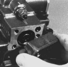 Remove the screw adjustable charge relief valve plug by loosening the lock nut (with a 1 1/16" hex wrench), and unscrewing the plug with a large screwdriver.