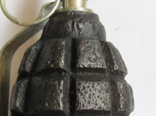 grenade with the lever under the fingers of the