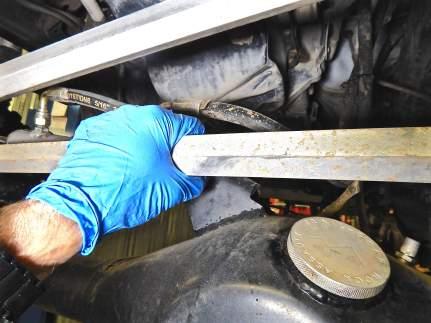 Step 28 While holding the tie rod and toe adjuster sleeve with a pipe wrench, loosen the driver side