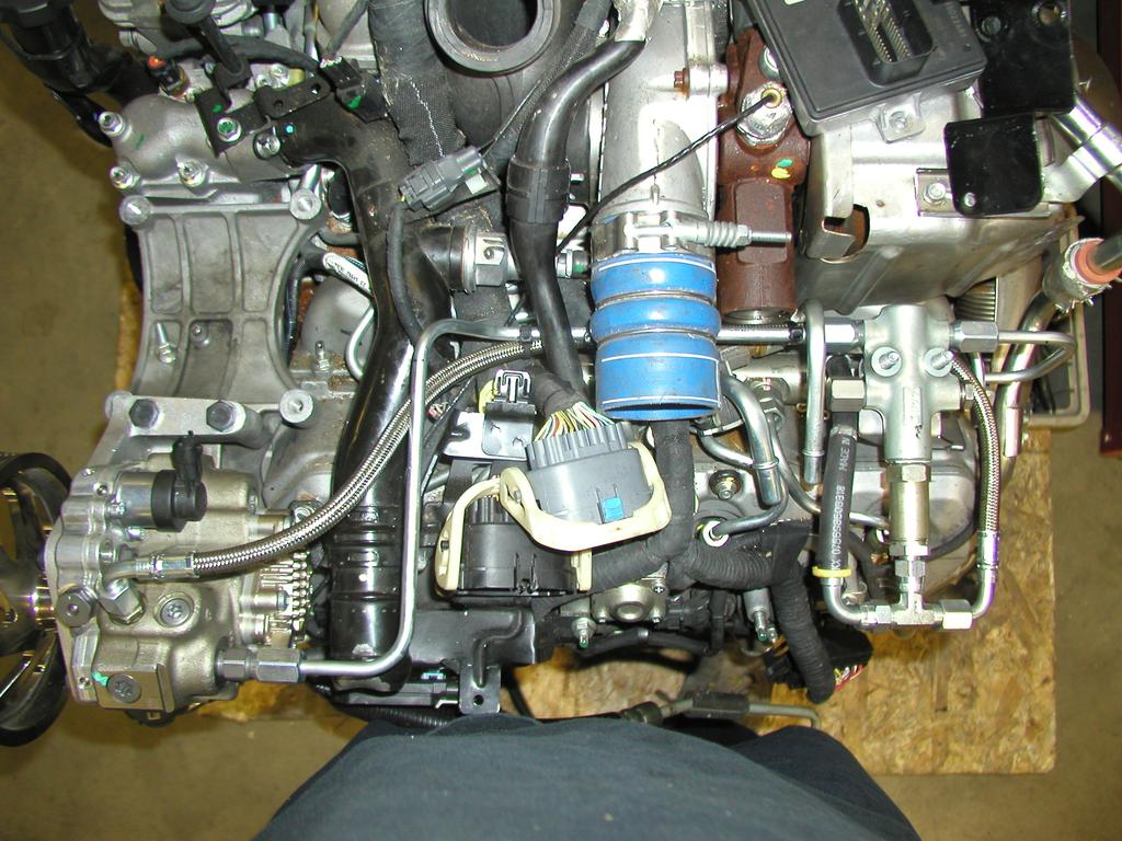 Using the three 10mm bolts and washers, install the bracket and pump on the engine mounts located next to the A/C compressor, Figure 12.