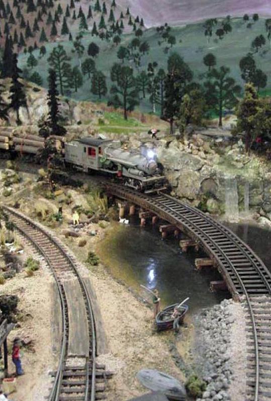 KJ Lumber #19 coasts down grade with a load of trees crossing the bridge over Vern Pond completely free-lance railroad set somewhere in the 1890-1920 s.