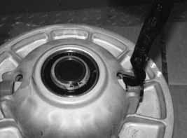 Remove the engine access panel and thoroughly clean all debris from the aluminum debris bracket and from the engine