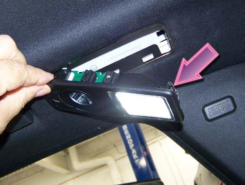 retainer clip (arrow). Lower the light assembly from the headliner, as shown.